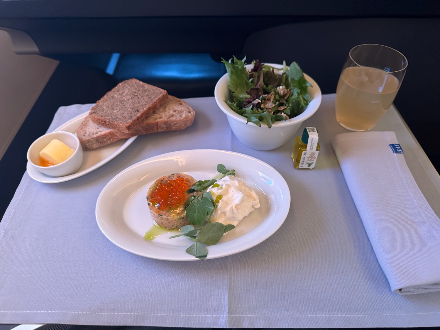 food on a plate with a salad and a glass of juice