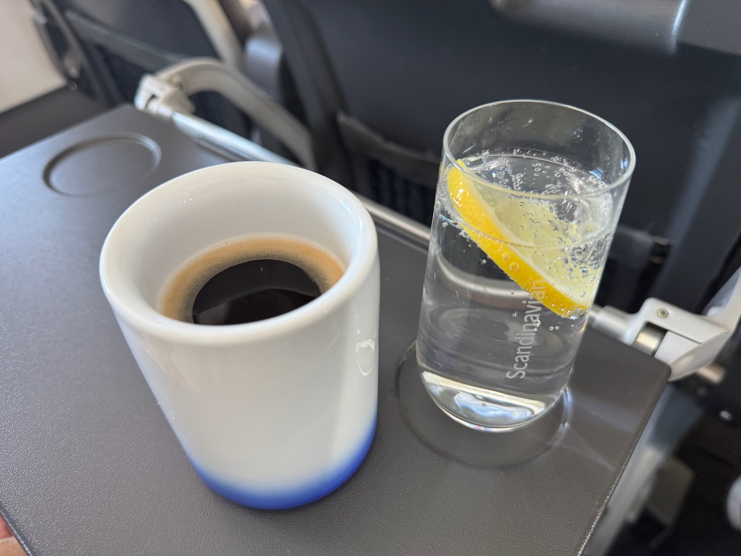 a cup of coffee and a glass of water on a table