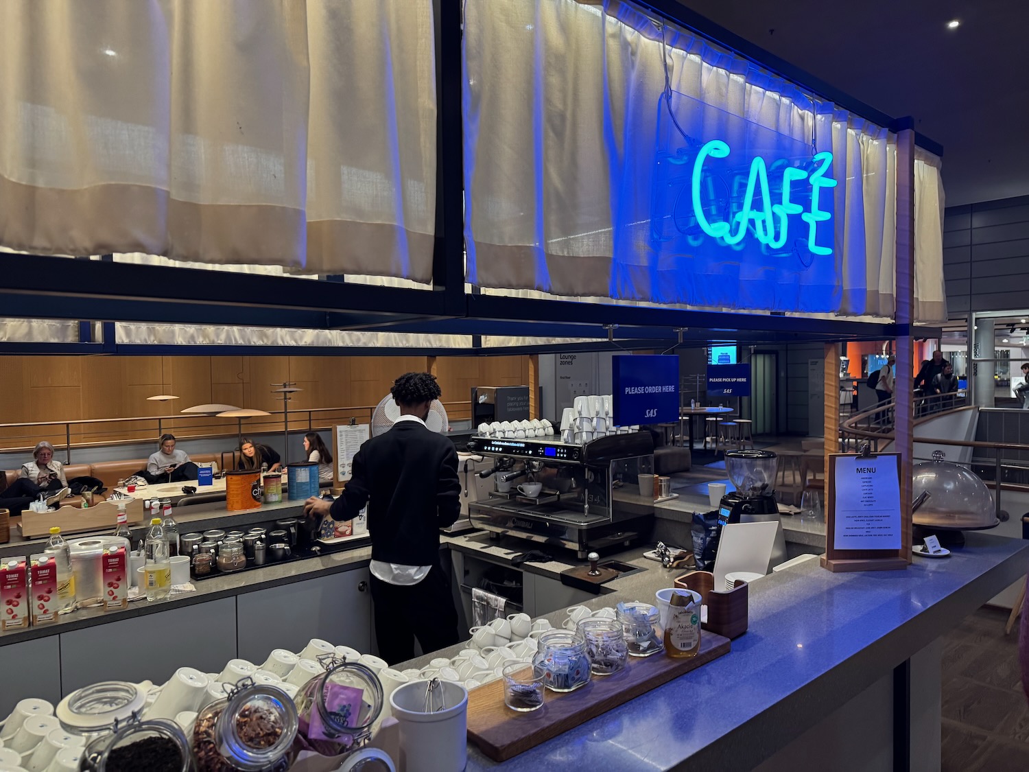 a man standing behind a counter in a cafe
