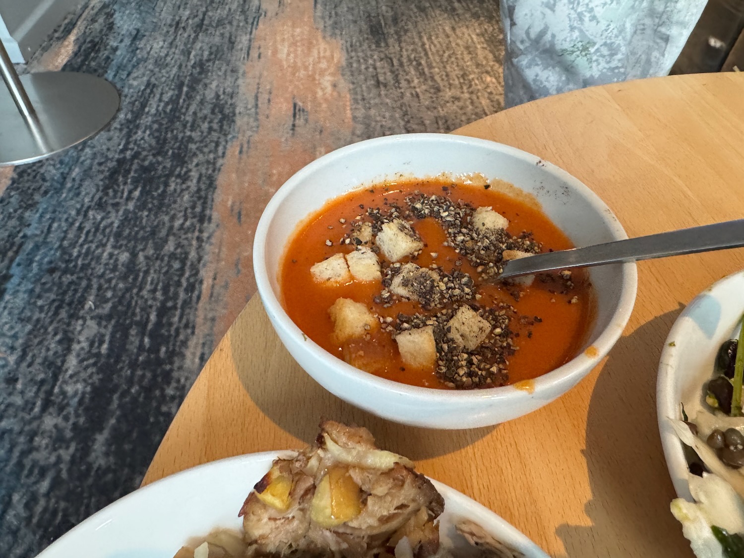 a bowl of soup with croutons and a spoon