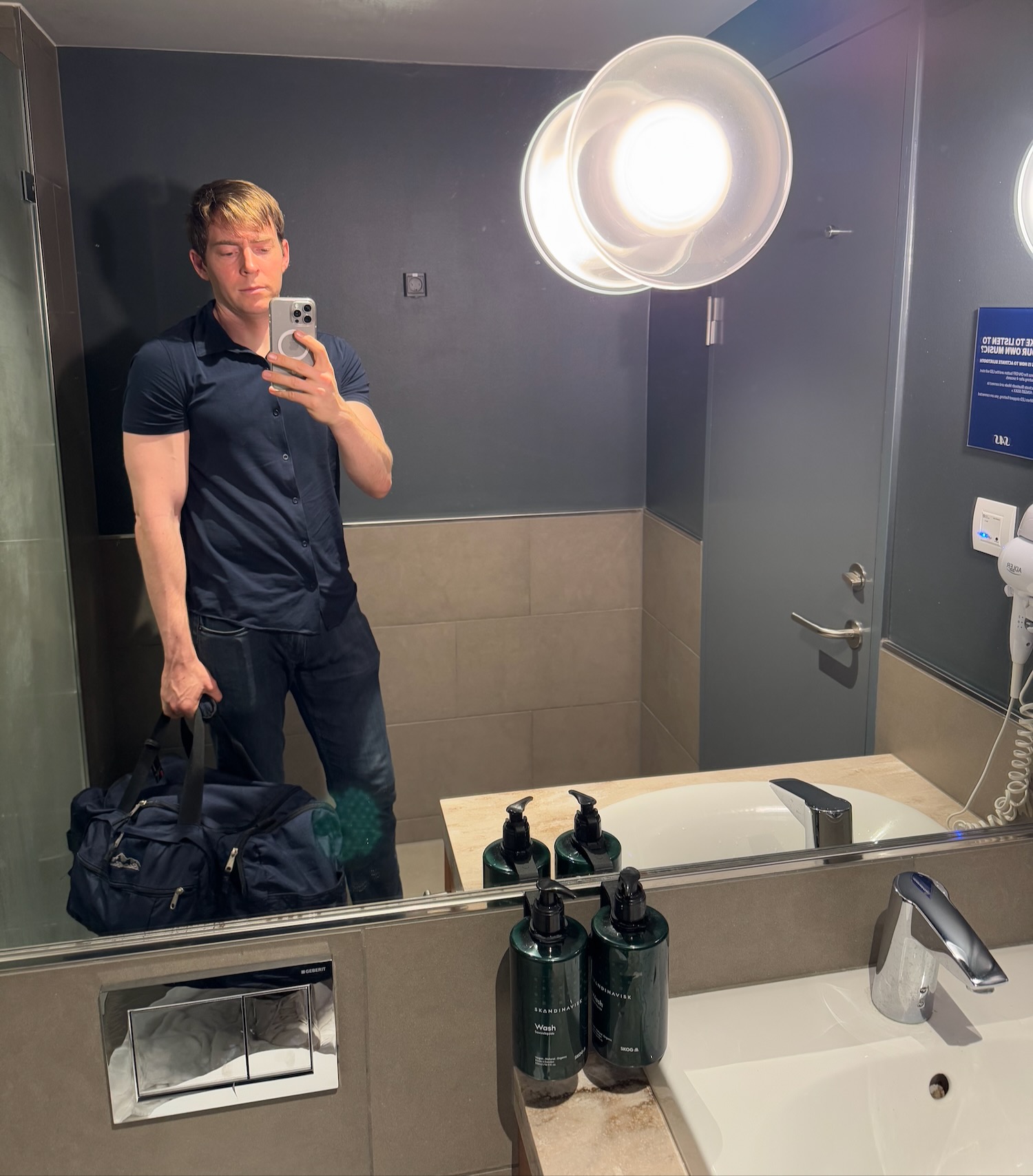 a man taking a selfie in a bathroom