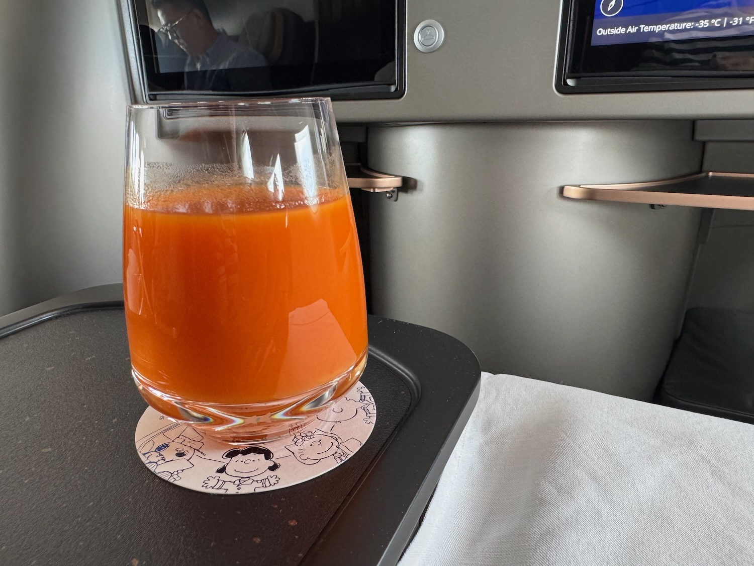 a glass of orange juice on a tray