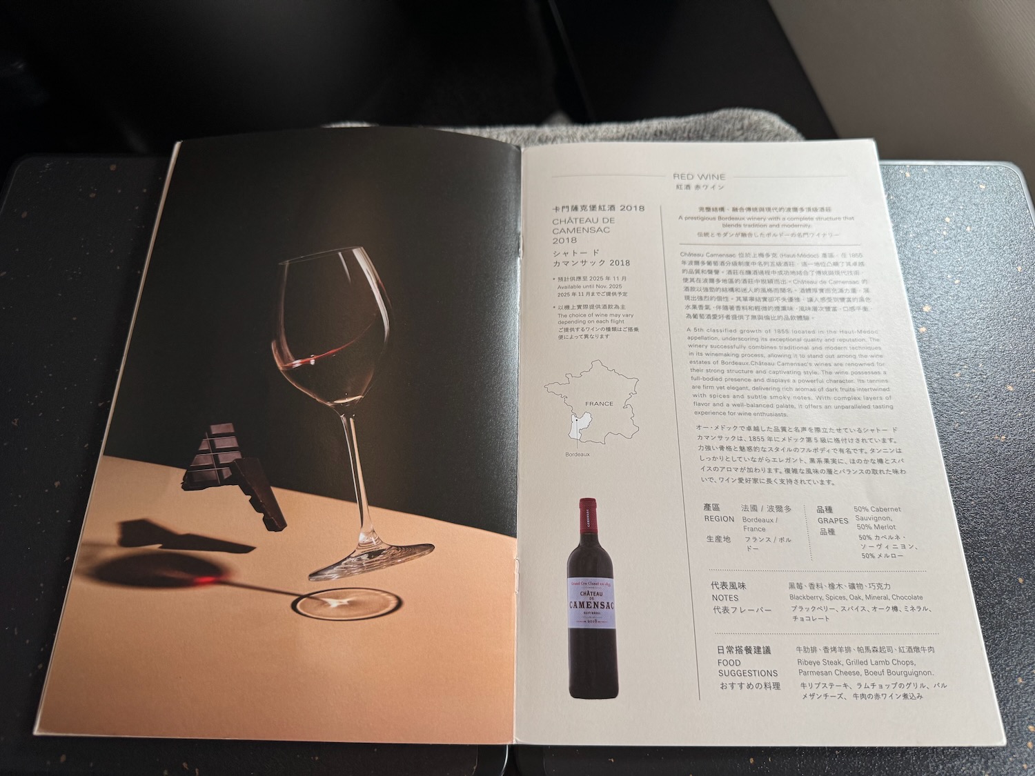 a book open to a table with a glass of wine and a bottle