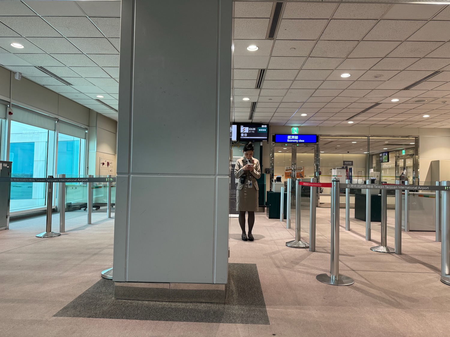 a woman standing in a hallway with a pillar