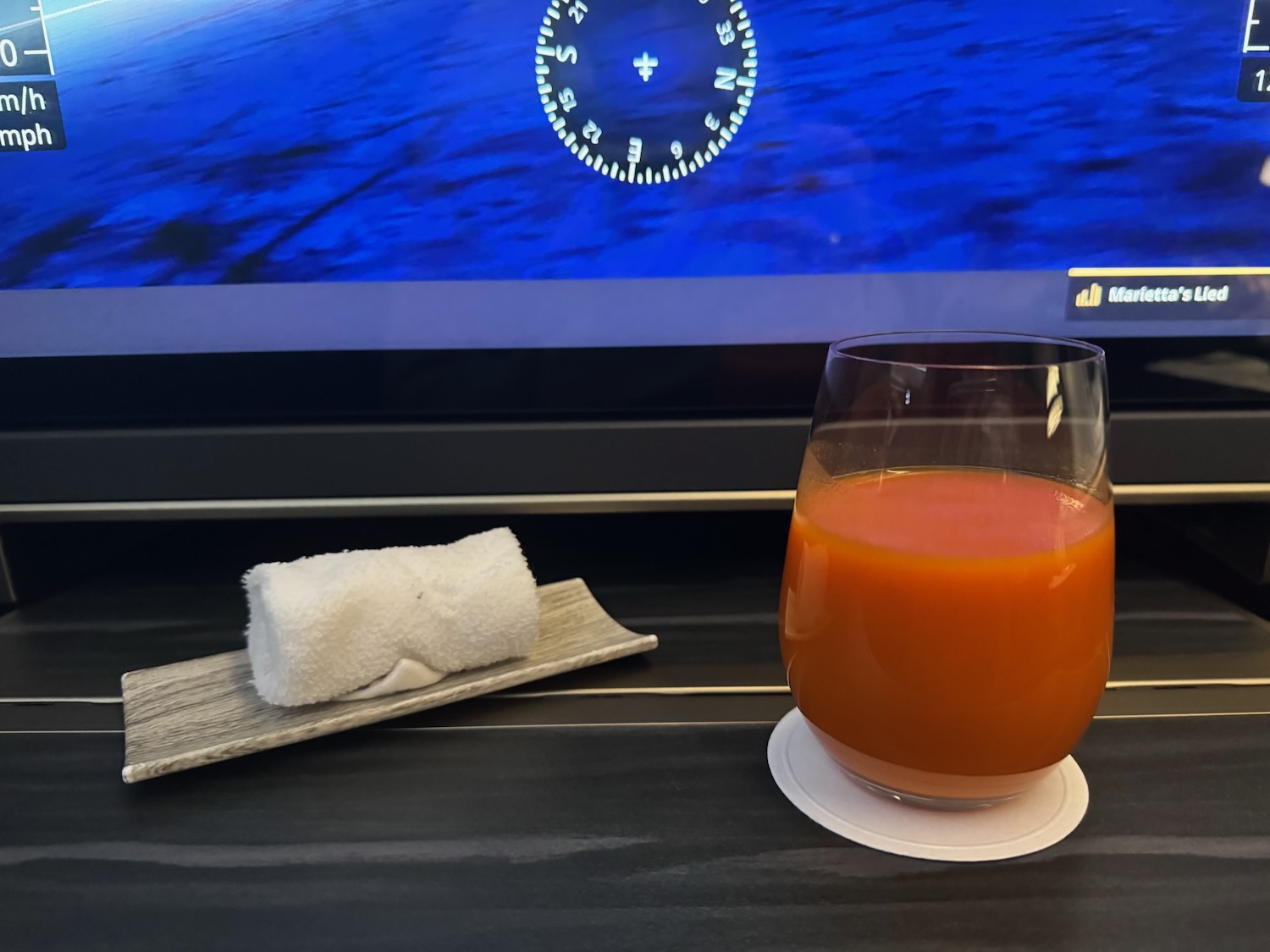 a glass of orange juice and a towel on a table