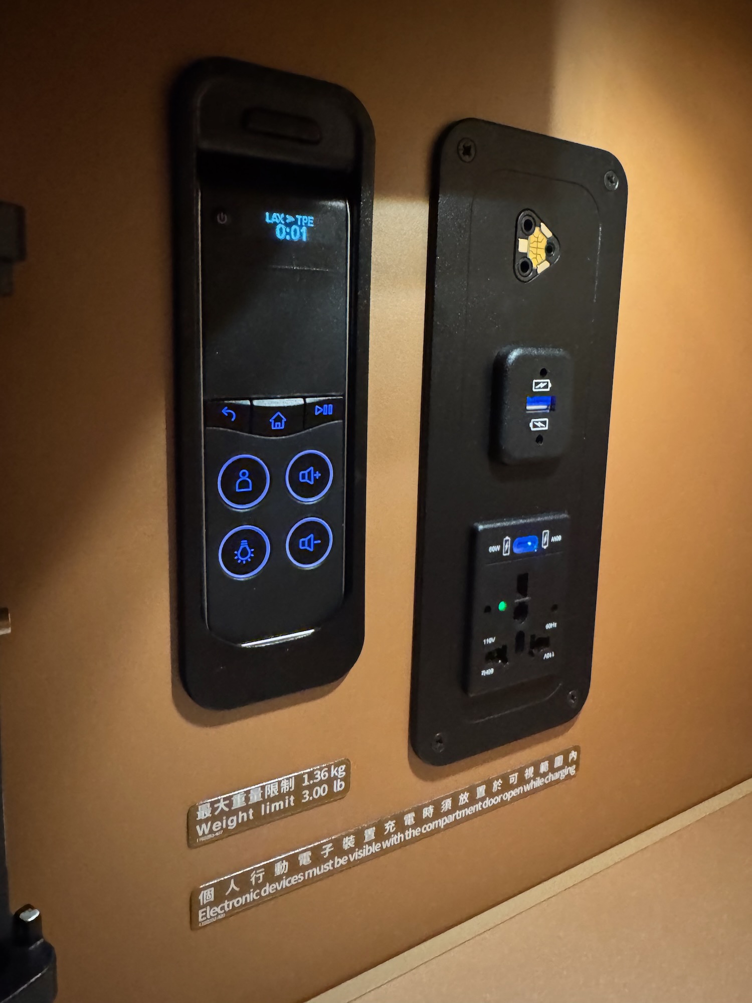 a black rectangular device with buttons and a black rectangle on the wall