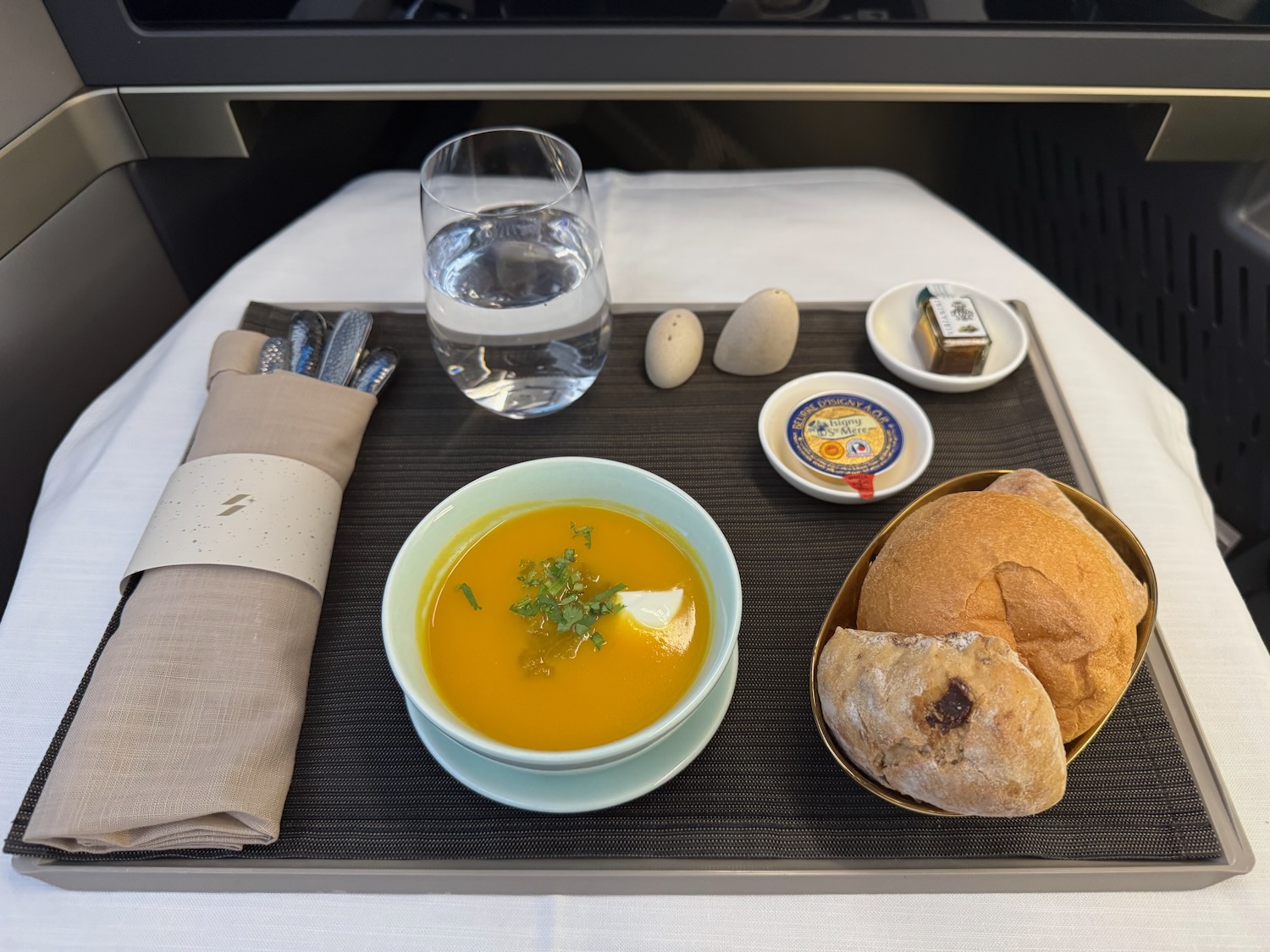 a tray with food and a glass of water on it