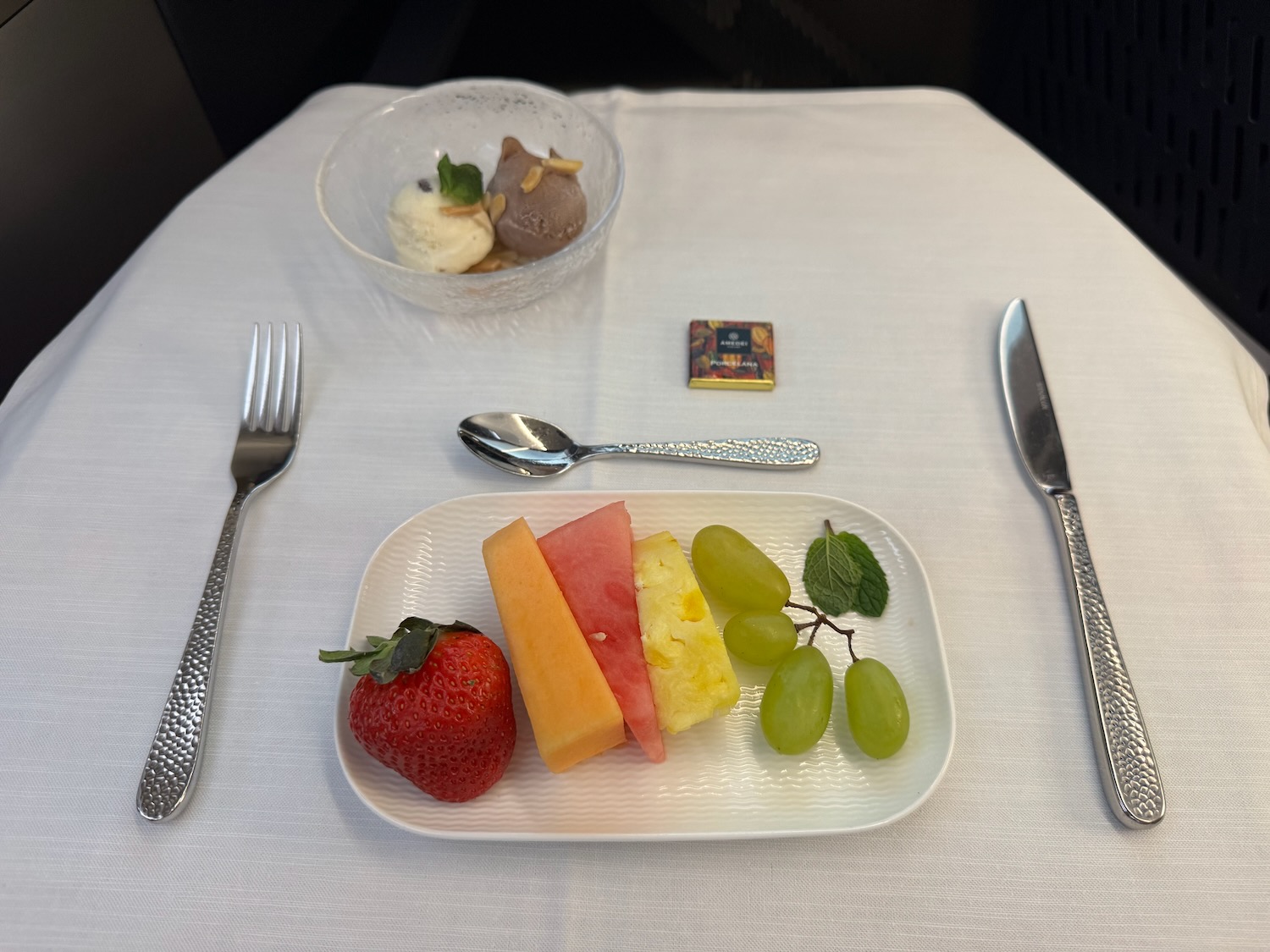 a plate of fruit and ice cream on a table