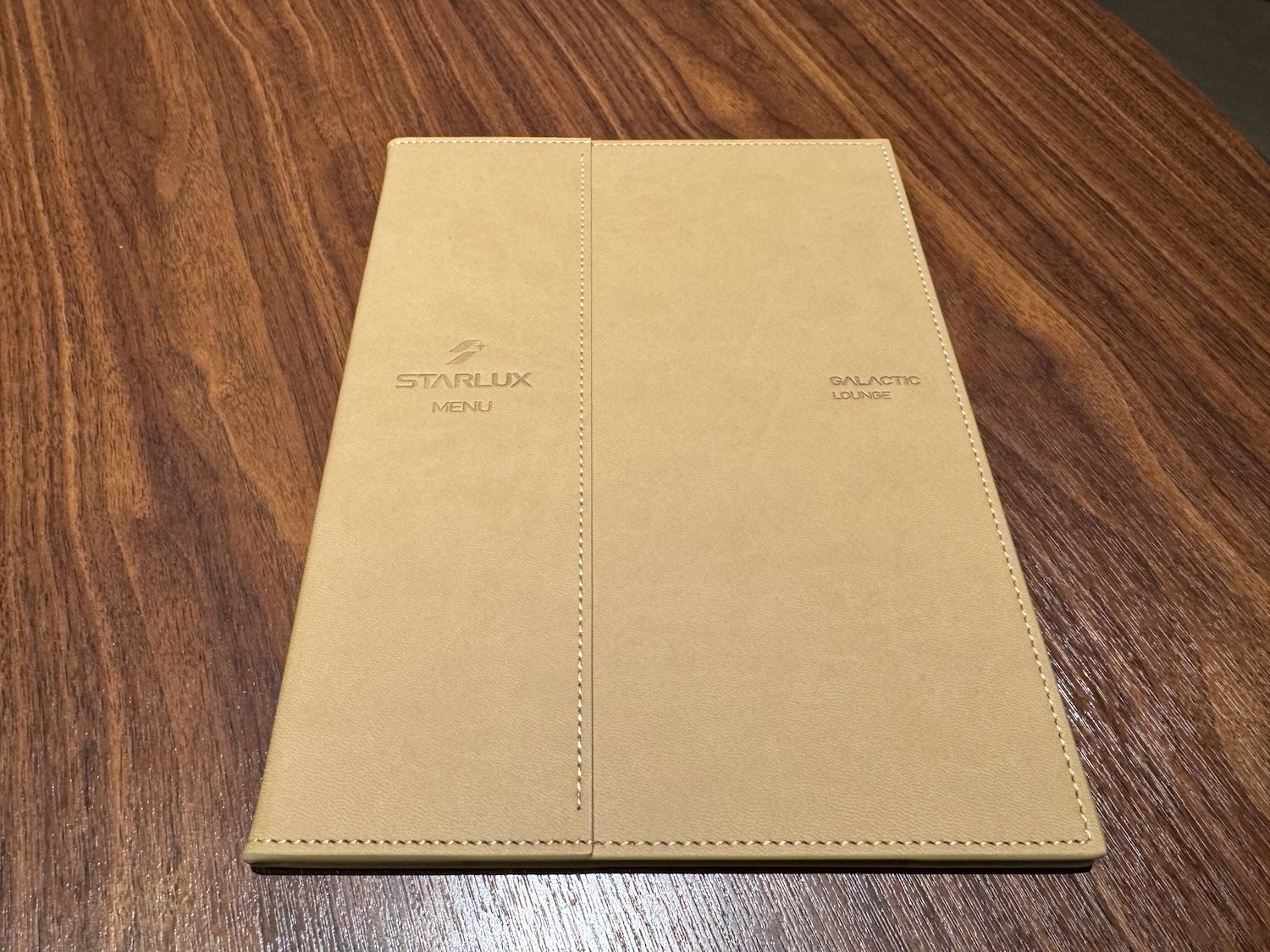 a tan menu on a wood surface