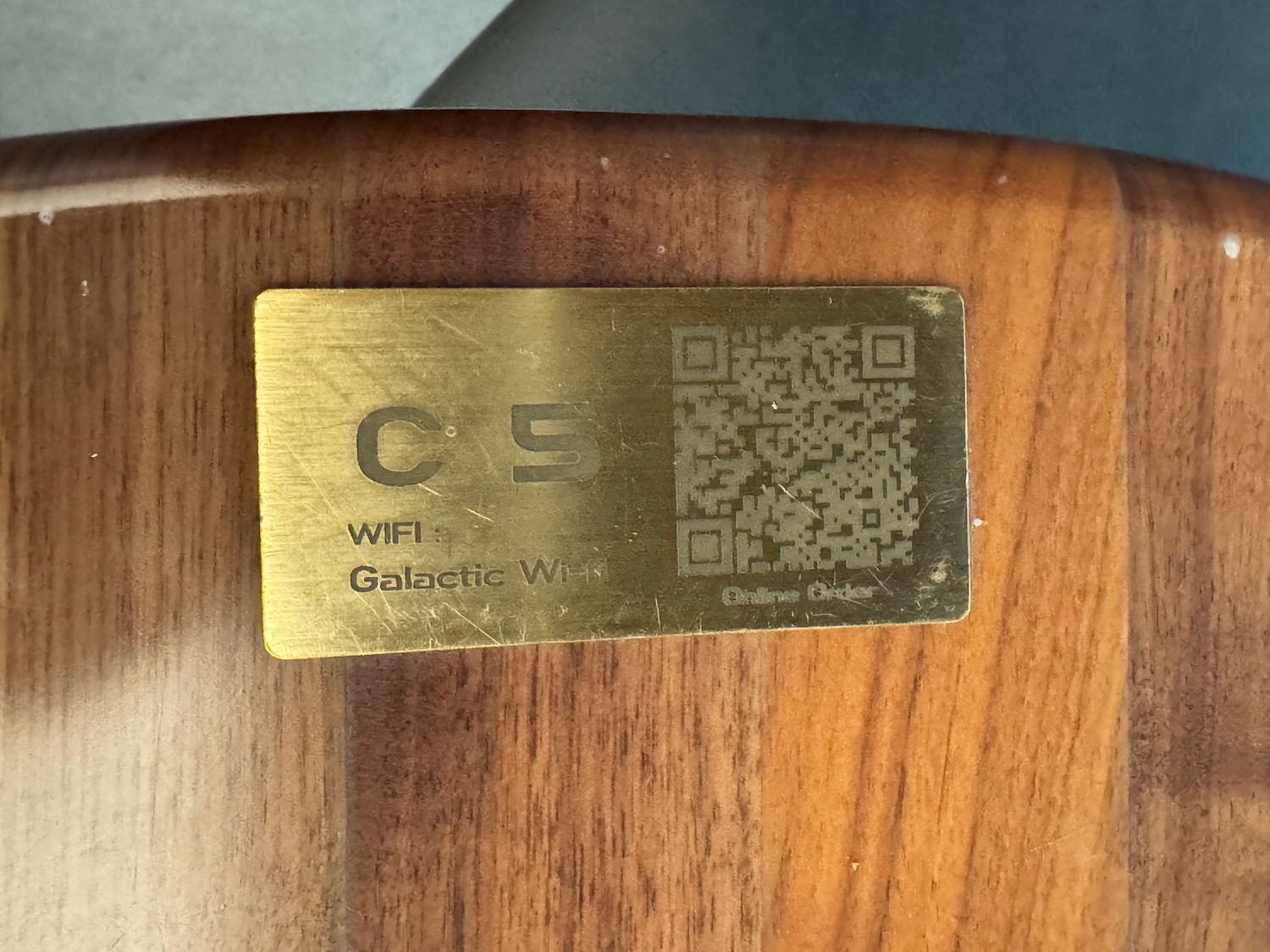 a gold rectangular metal plate with a qr code on it