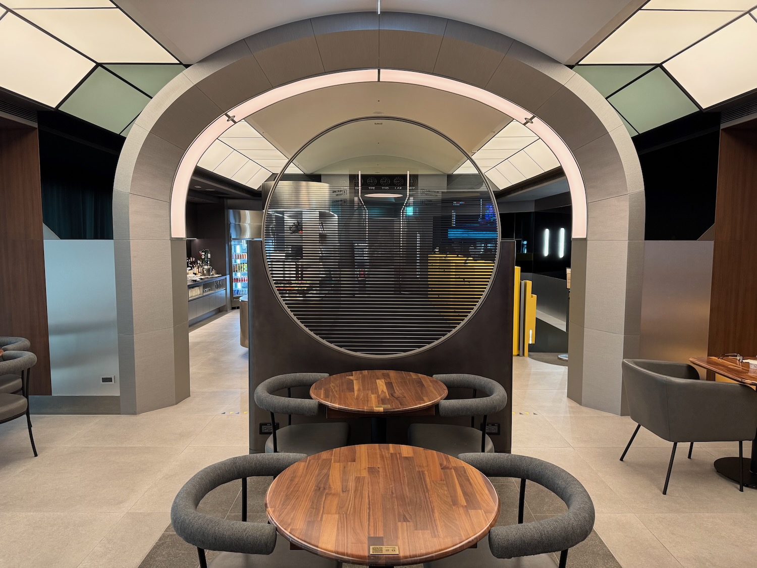 a round table and chairs in a room with a circular arch