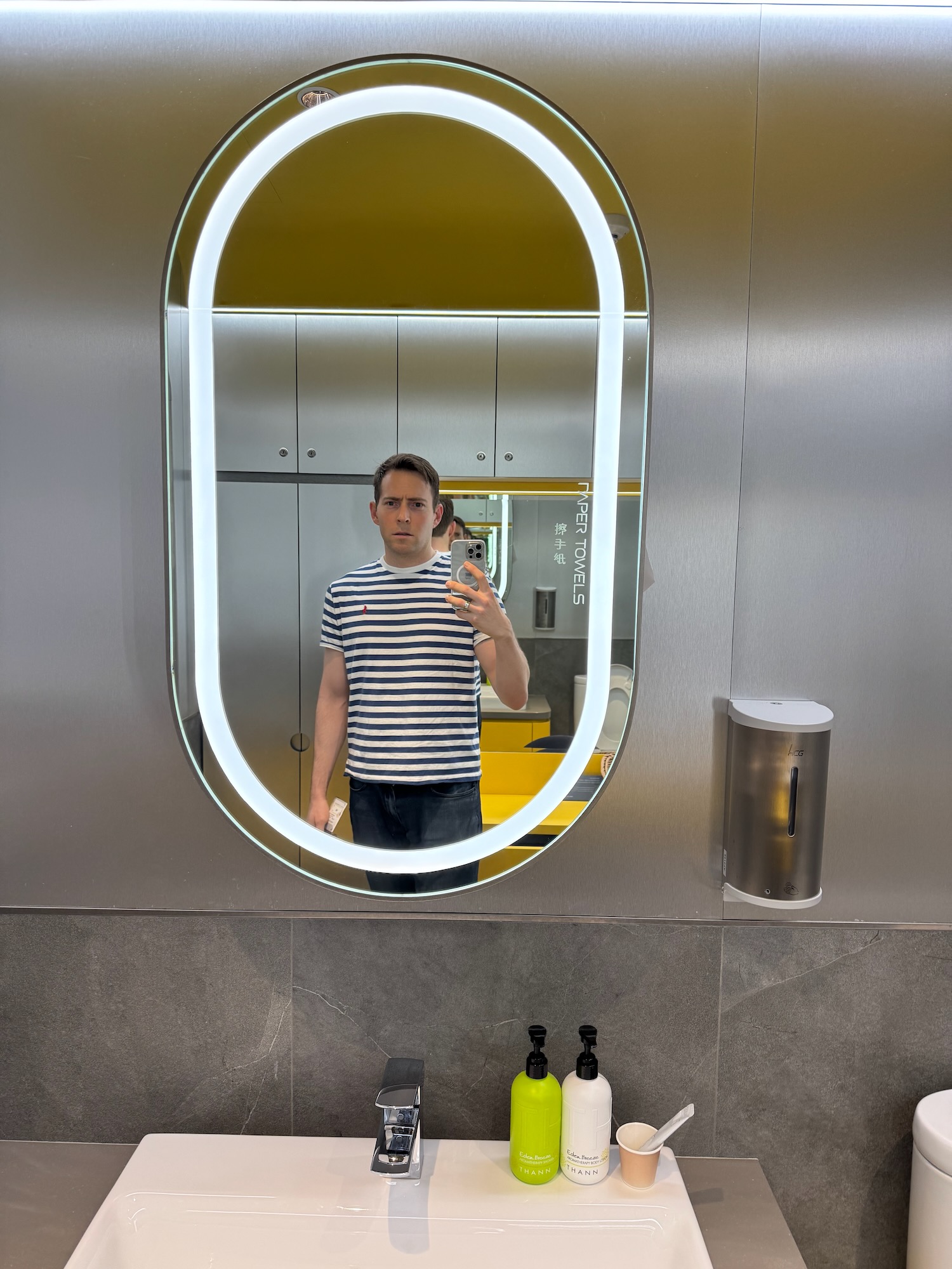 a man taking a selfie in a bathroom mirror