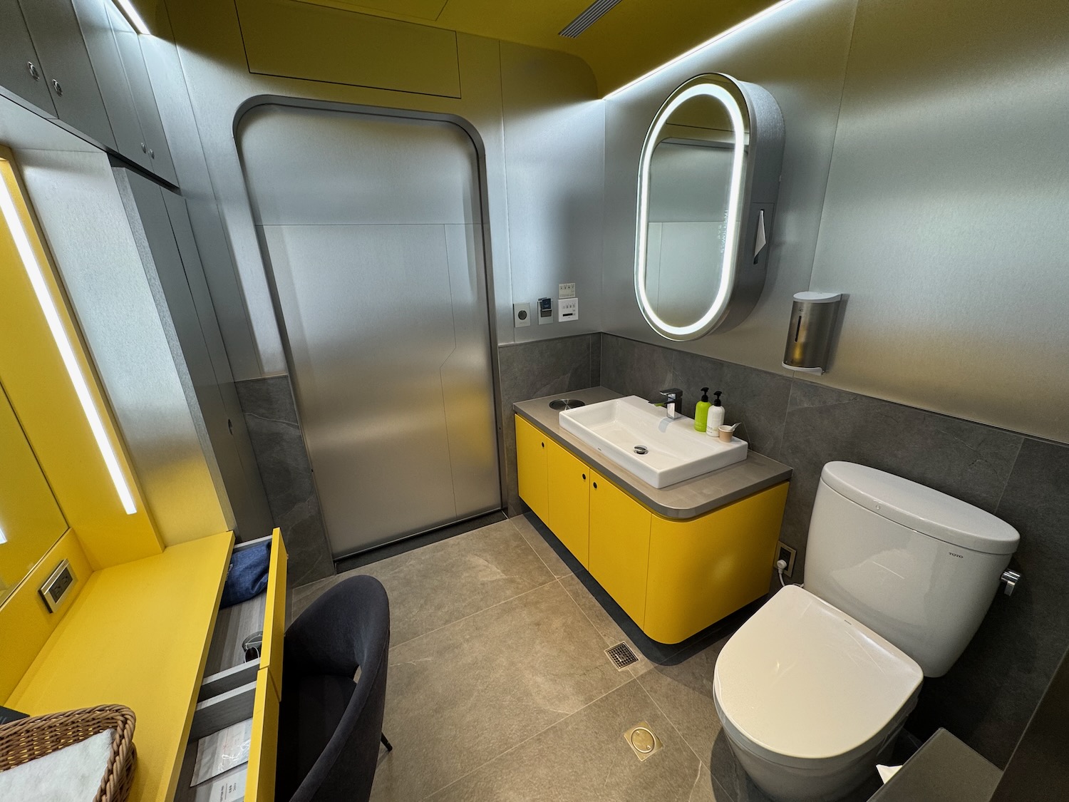 a bathroom with yellow cabinets and a sink