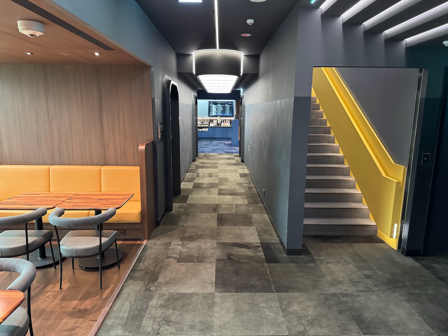 a hallway with stairs and tables