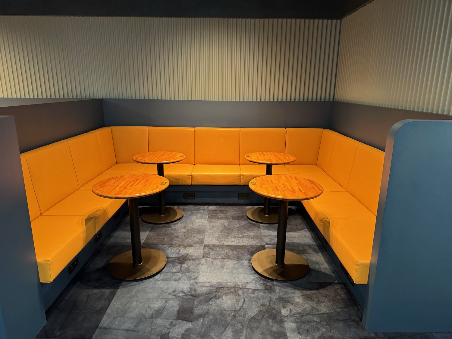 a booth seating with orange couches and tables