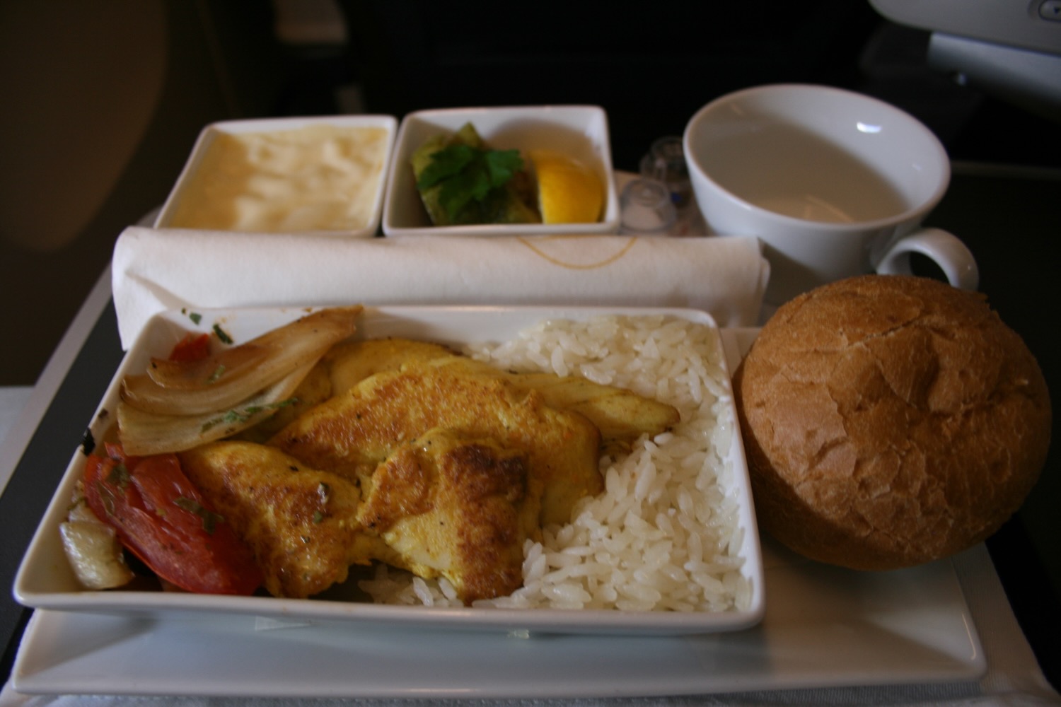 a plate of food with a roll and a bowl of sauce