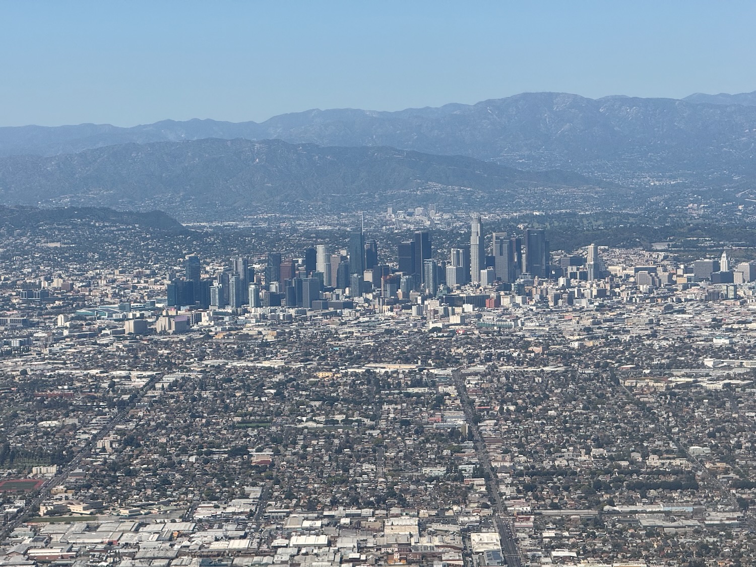 a city with many buildings and mountains in the background