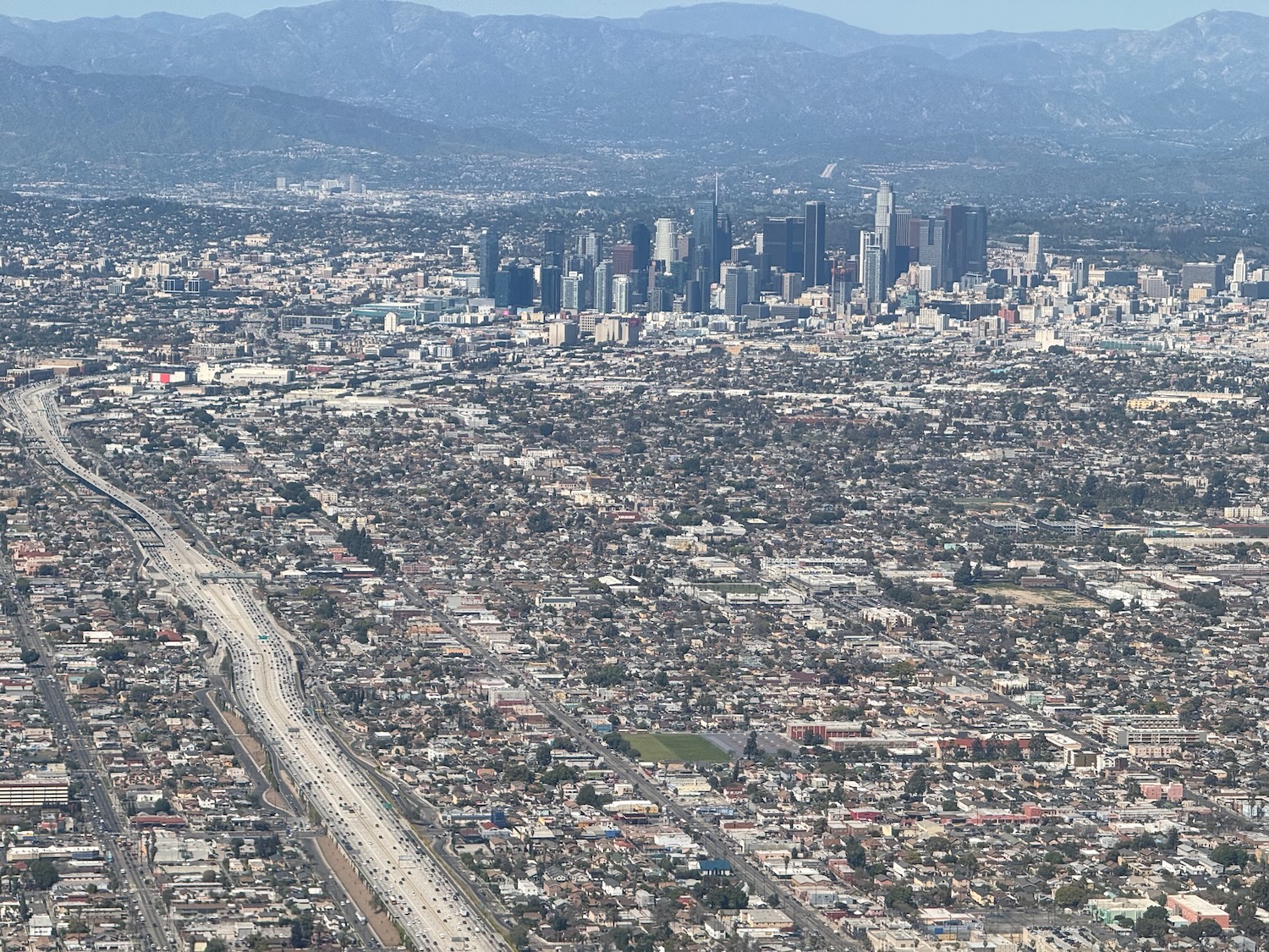 a city with a road and mountains in the background
