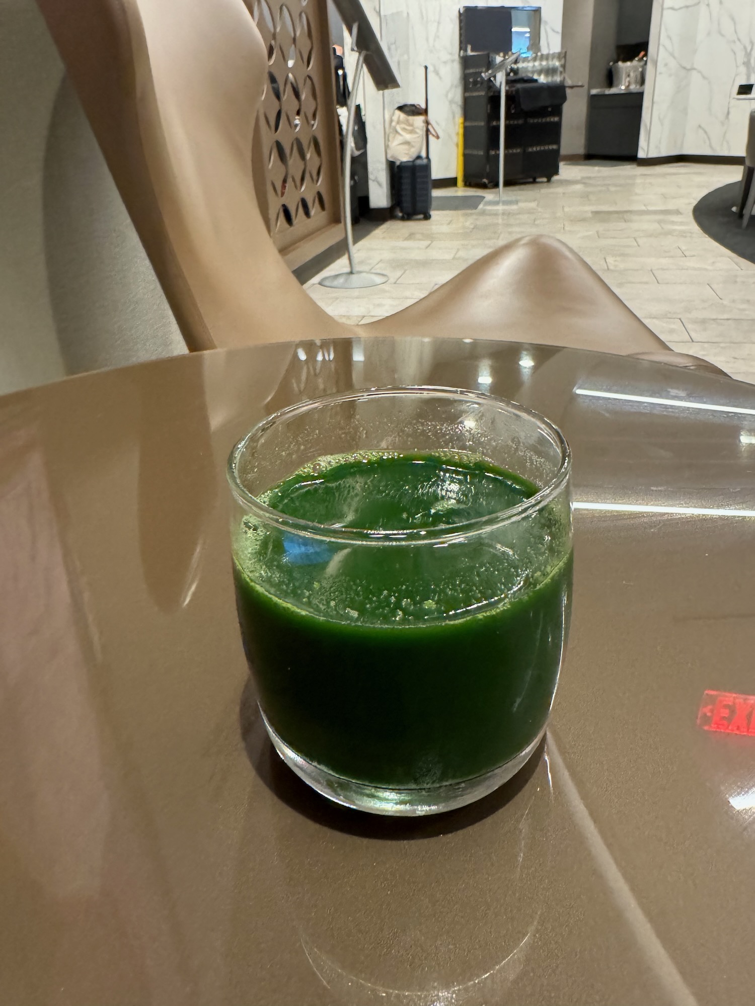 a glass of green liquid on a table