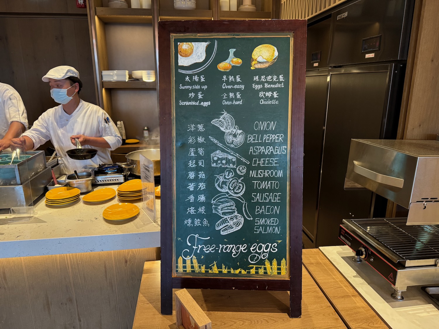 a man in a white hat cooking in a restaurant