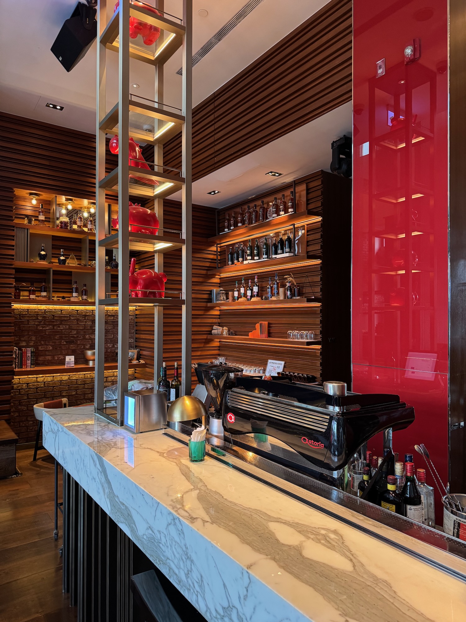 a bar with a black machine and red dishes on it