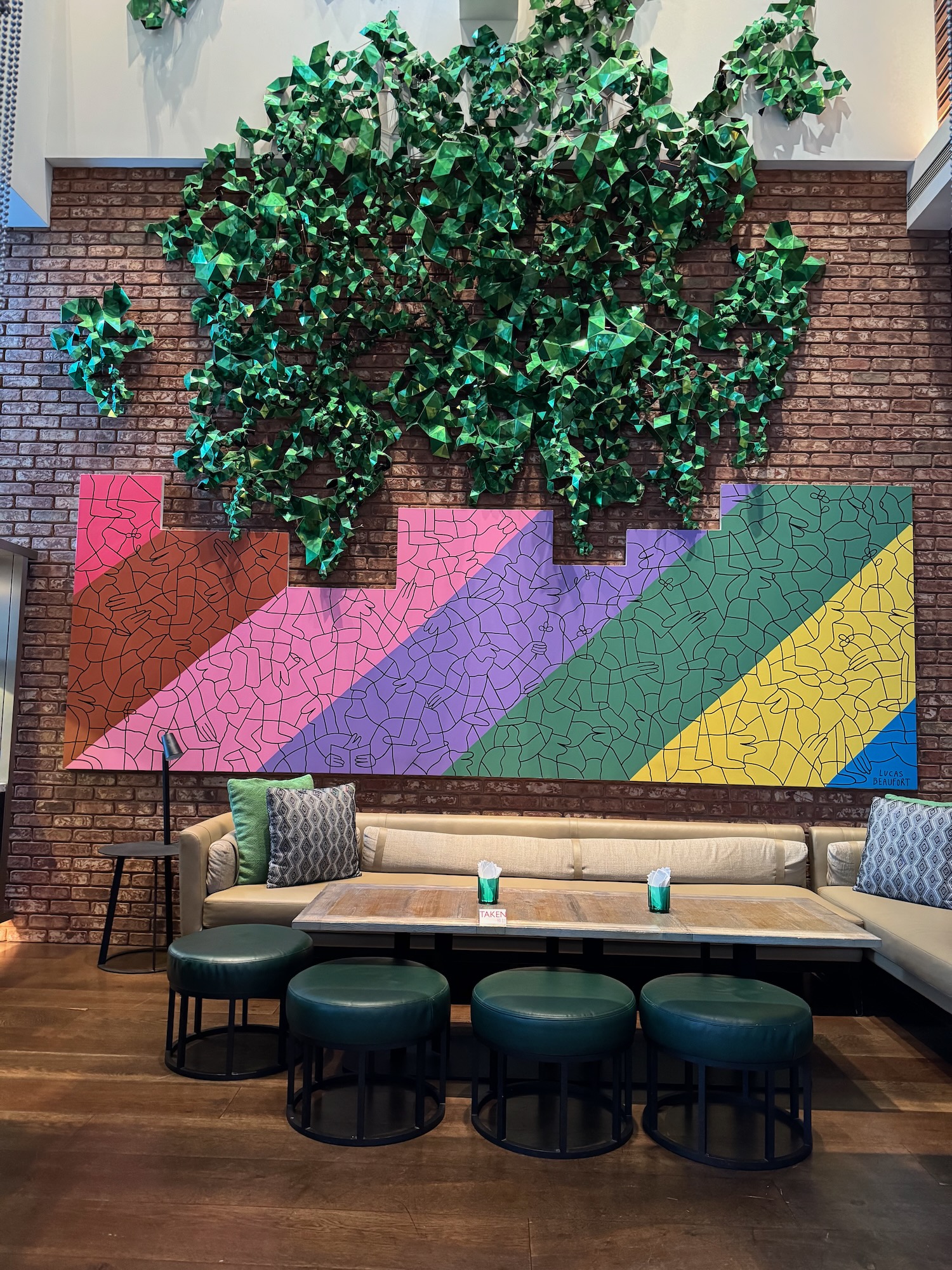 a room with a wall of green plants and a table