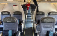 a woman standing in the middle of an airplane