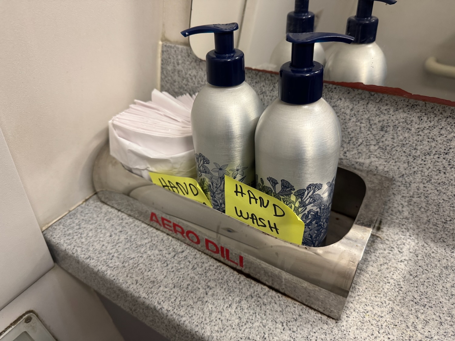 a group of hand wash bottles and napkins in a sink