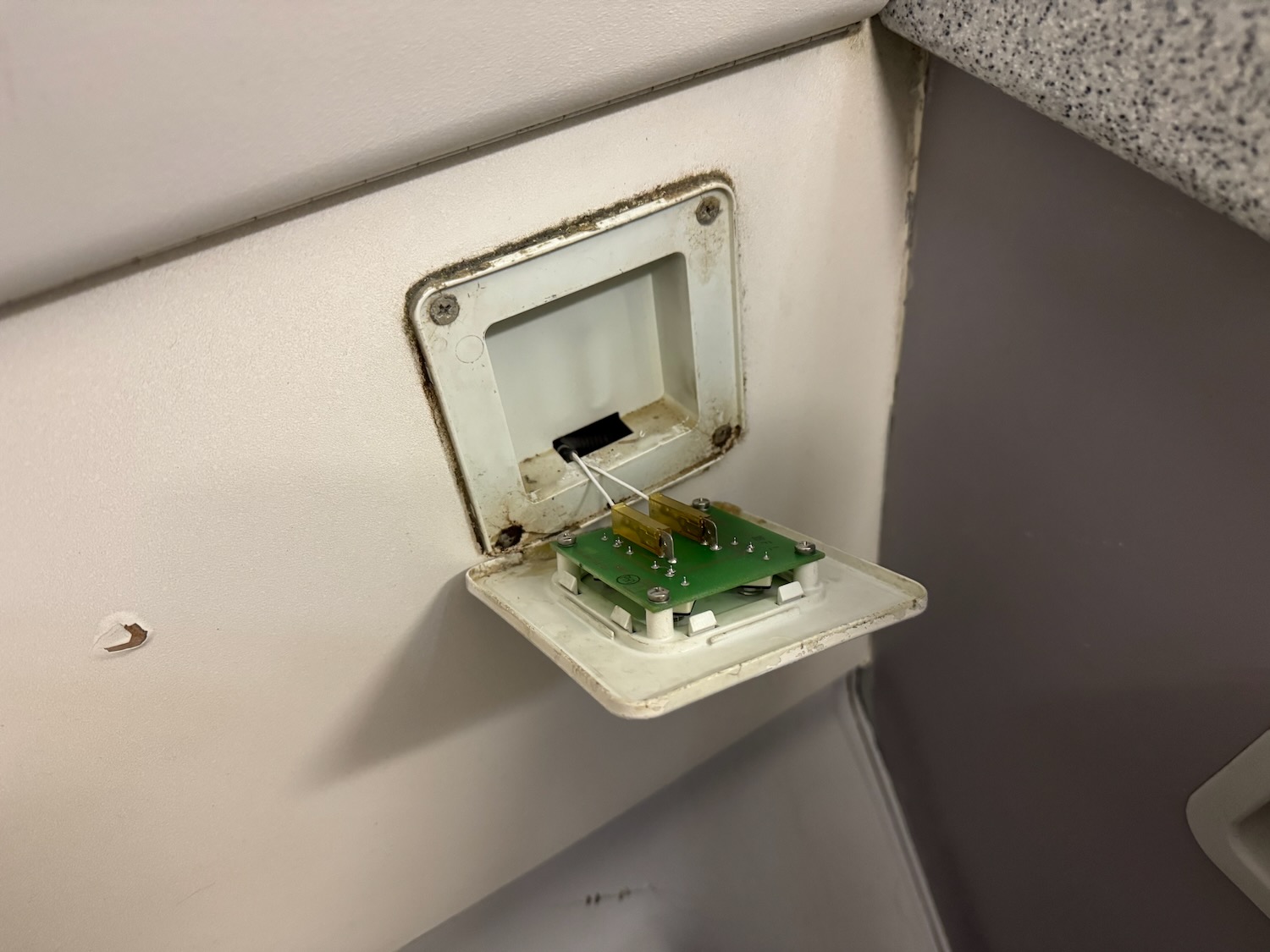 a small green circuit board in a white wall