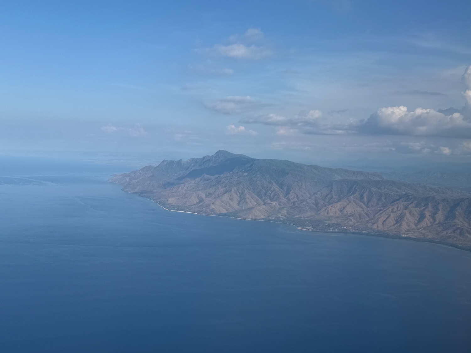 a large body of water with a mountain in the distance