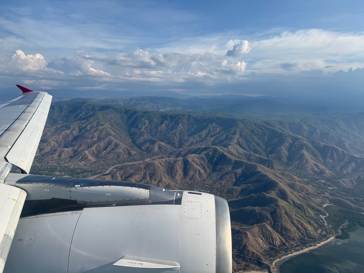 an airplane wing and view of mountains and land