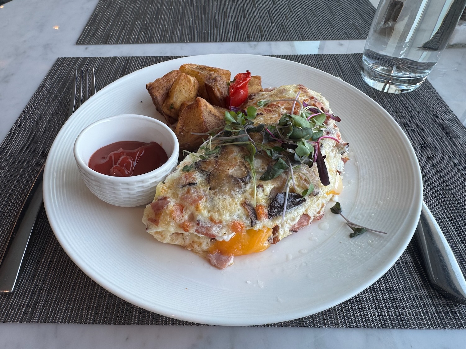 a plate of food with a small bowl of ketchup