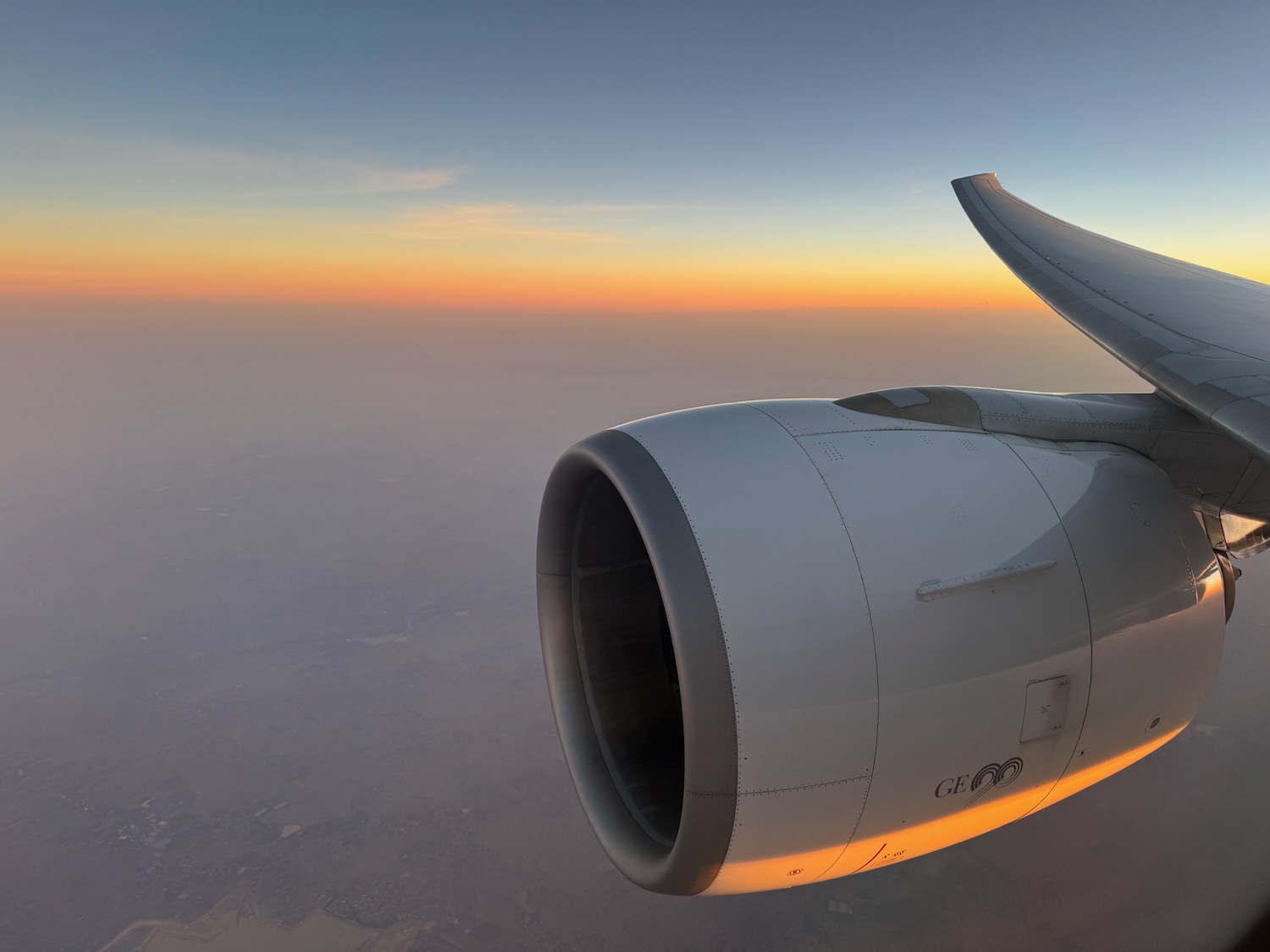 an airplane wing with a sunset in the background