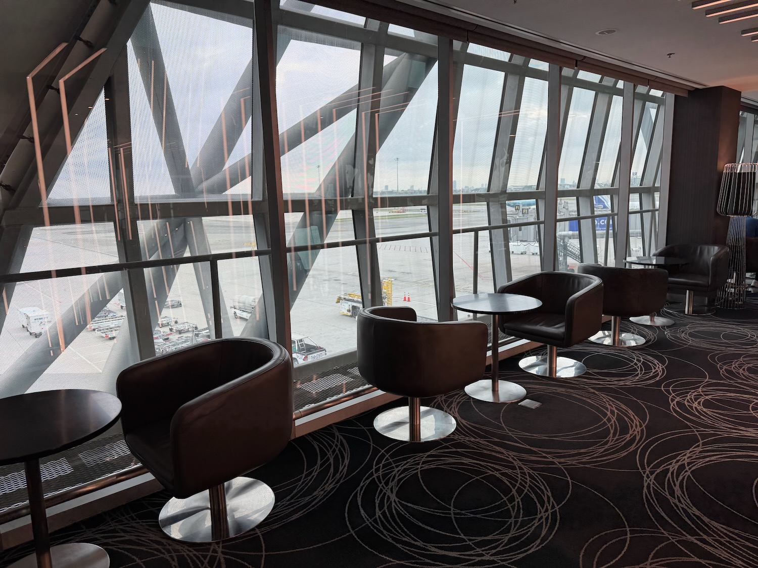 a room with chairs and tables by a window
