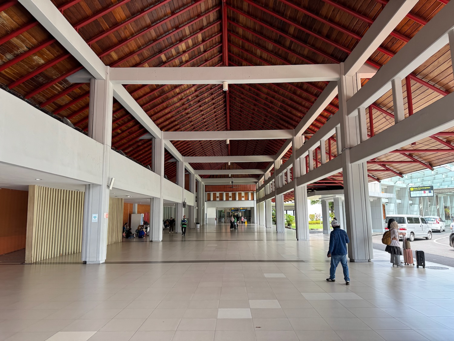 a large white building with pillars and people walking