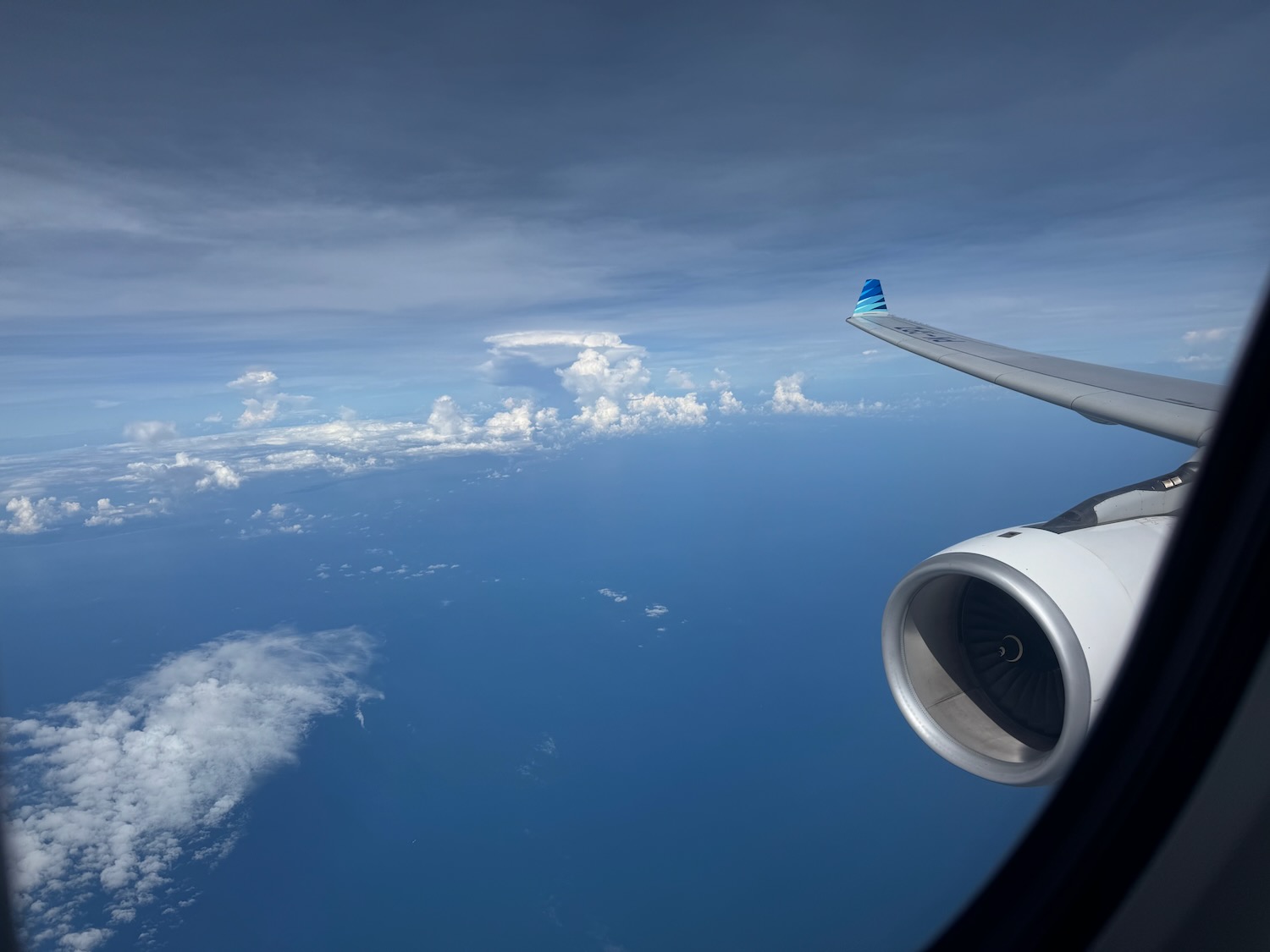 an airplane wing and engine above the clouds