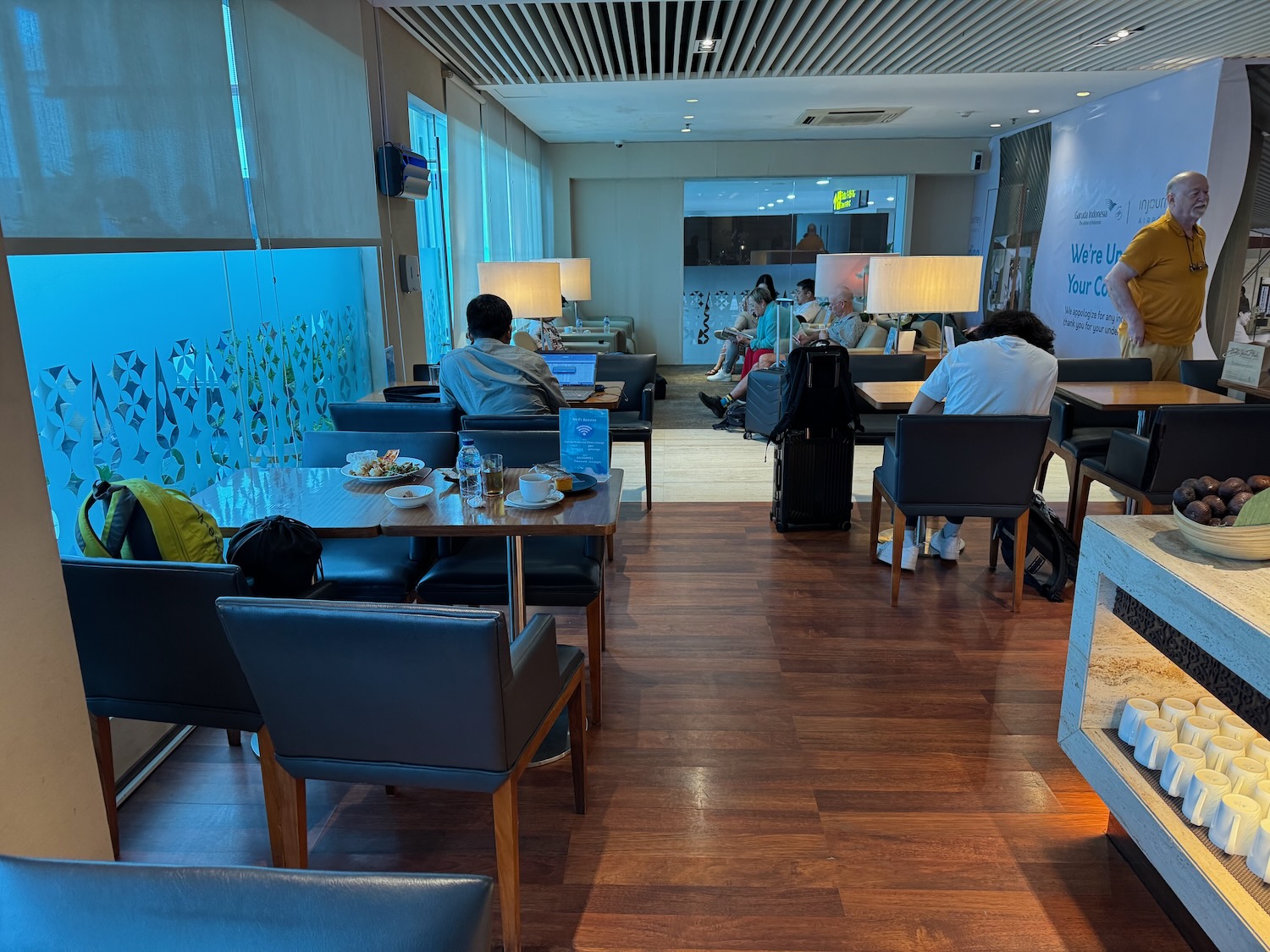a group of people sitting at tables in a room with chairs and a fireplace
