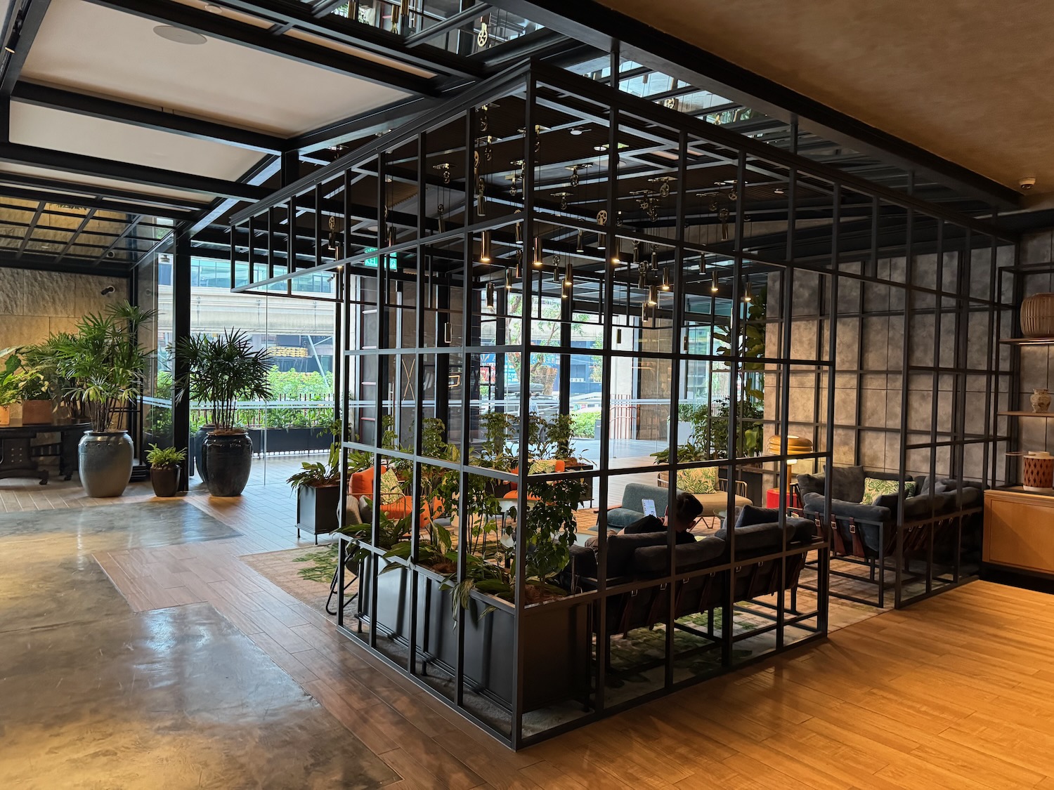 a room with a glass wall and a person sitting on a couch