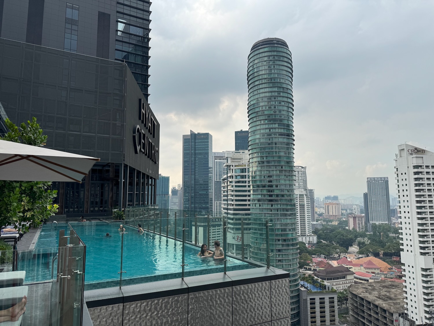 people in a pool on a rooftop overlooking a city