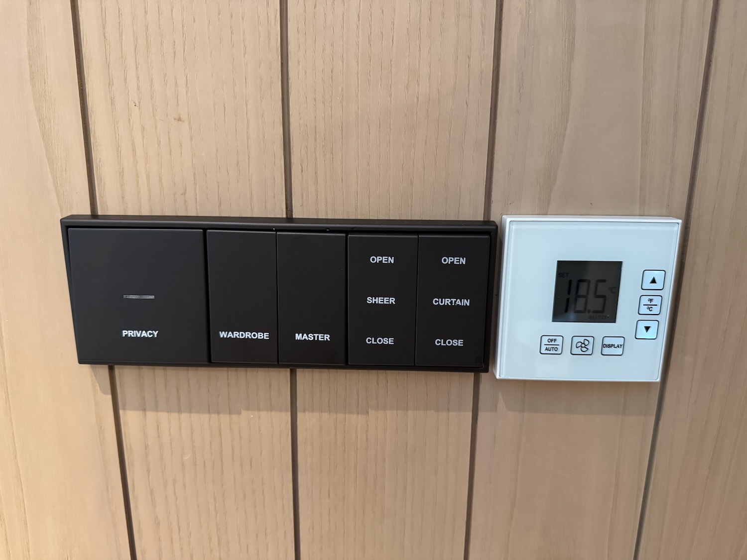 a switch and a white switch on a wood wall