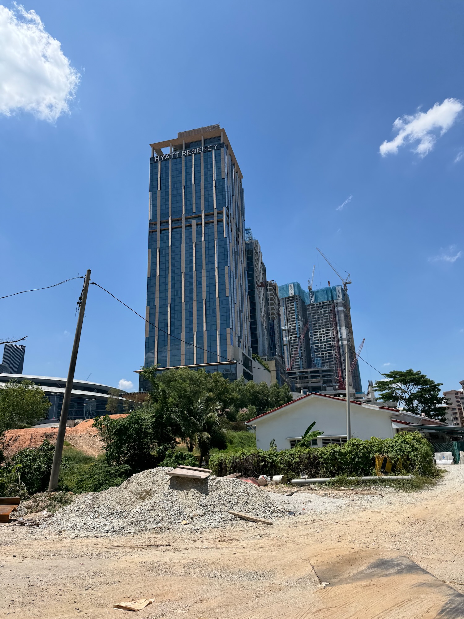 a building with a lot of trees and a dirt road