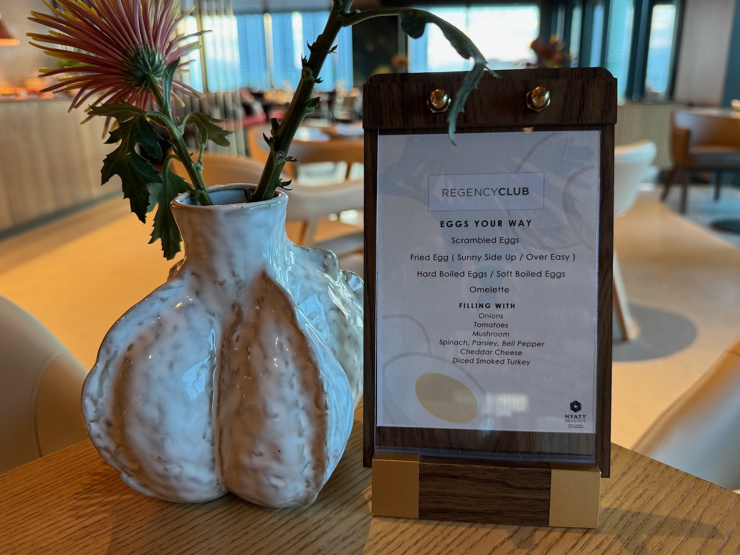 a flower in a vase next to a menu