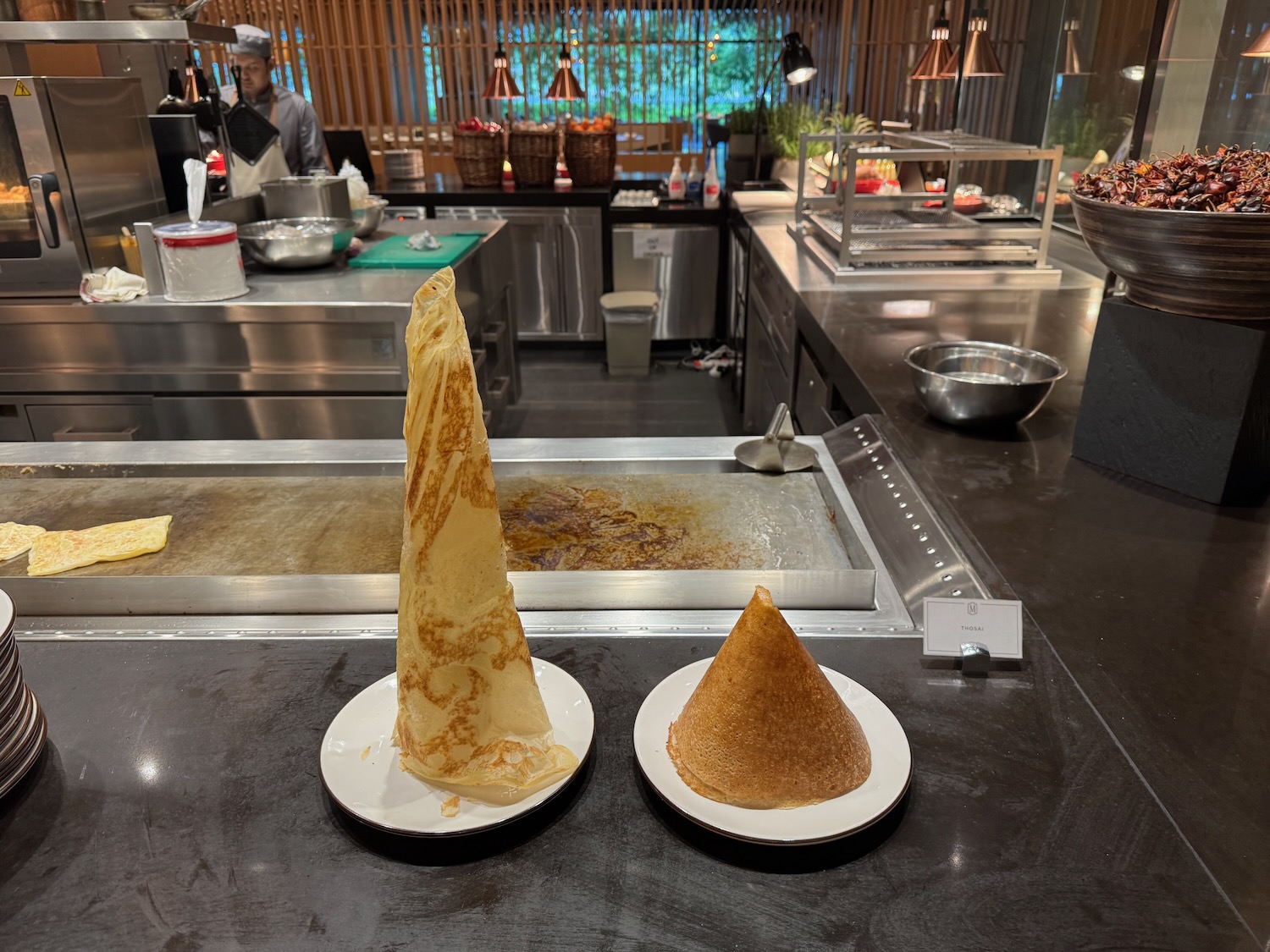 a pancake cone shaped food on plates in a kitchen