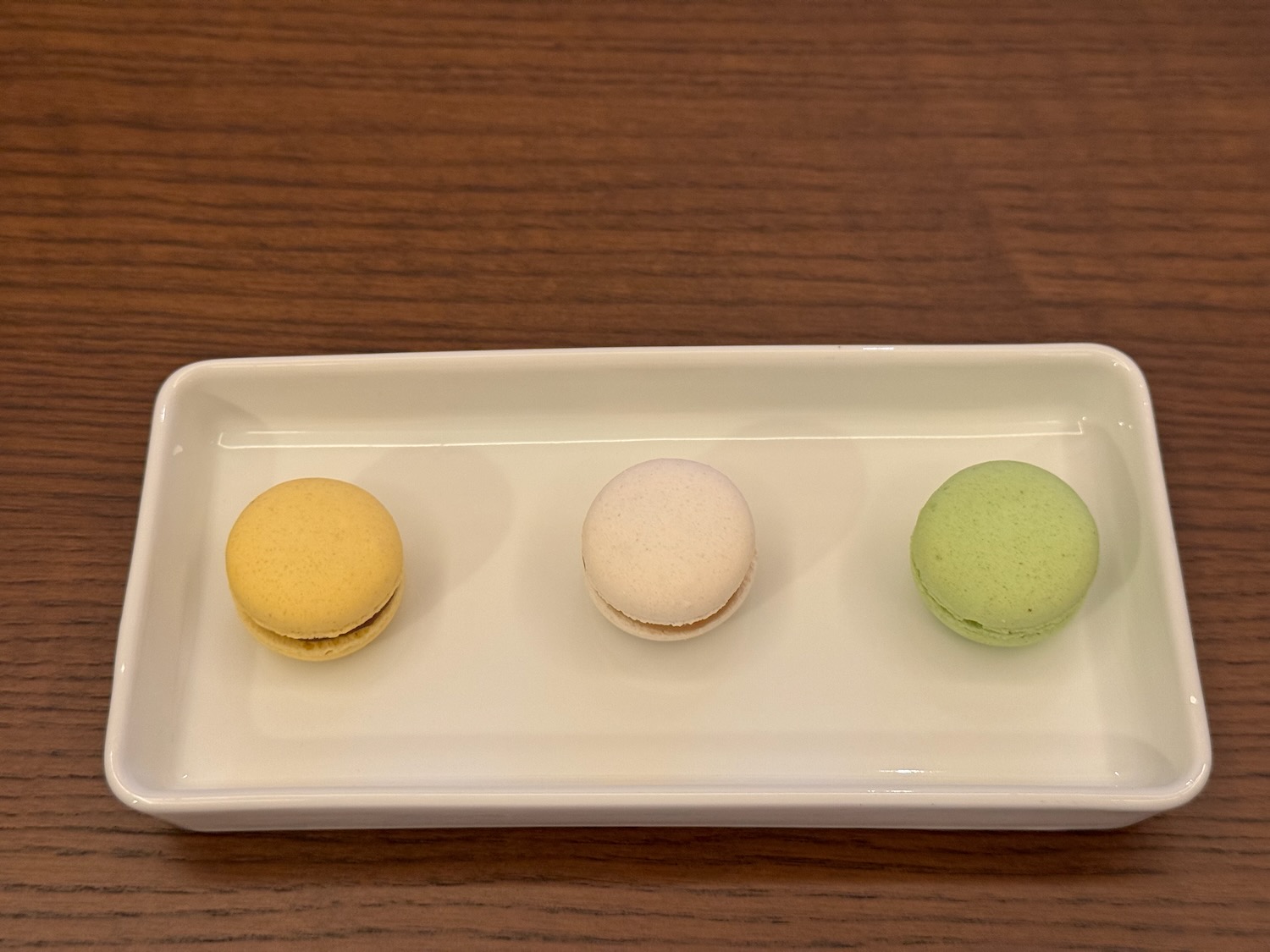 a white rectangular plate with three colorful cookies on it