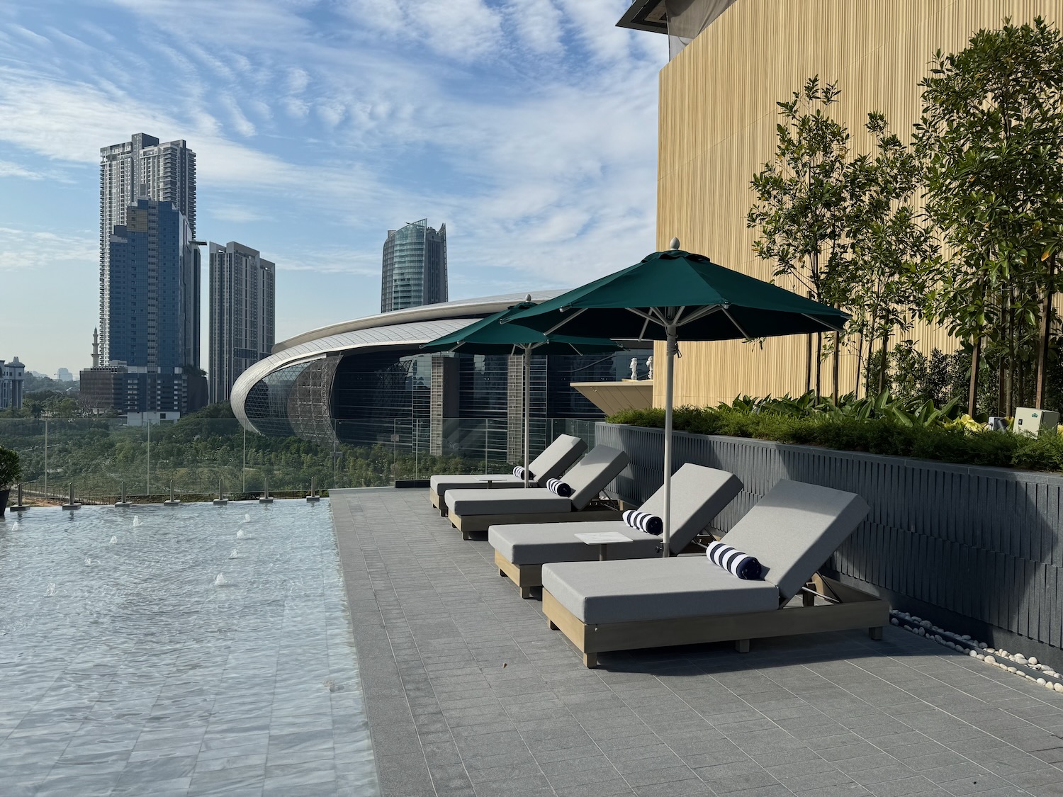 a pool with chairs and umbrellas by a building