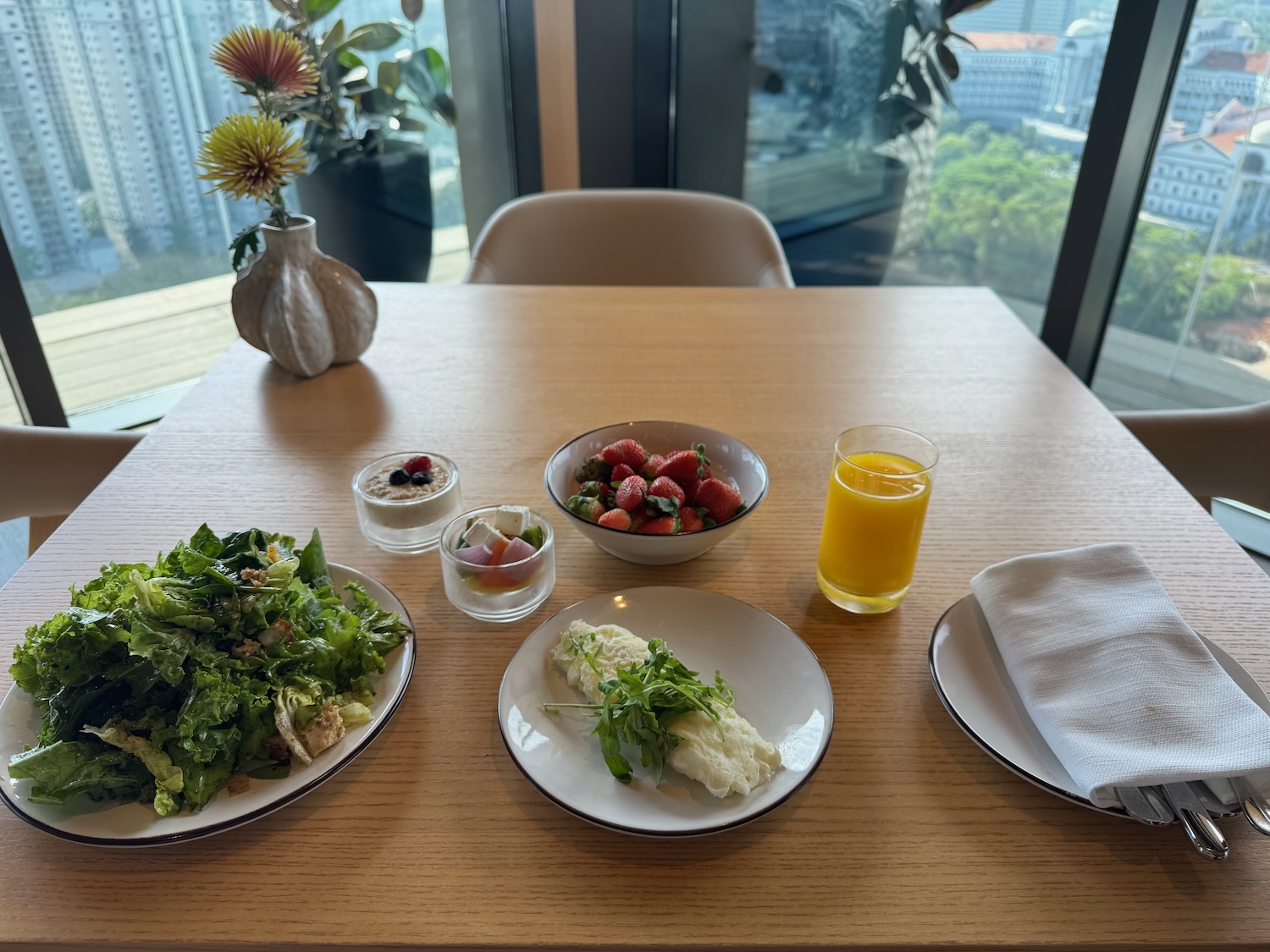 a table with plates of food and a glass of juice