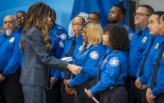 a woman shaking hands with police officers