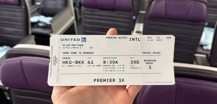 a hand holding a ticket in front of chairs