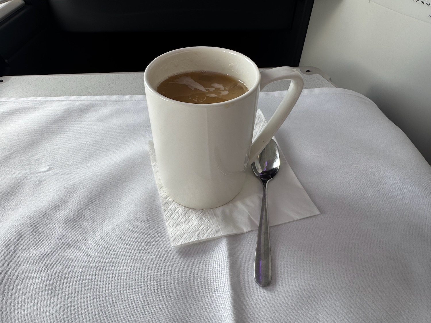 a cup of coffee with a spoon on a napkin