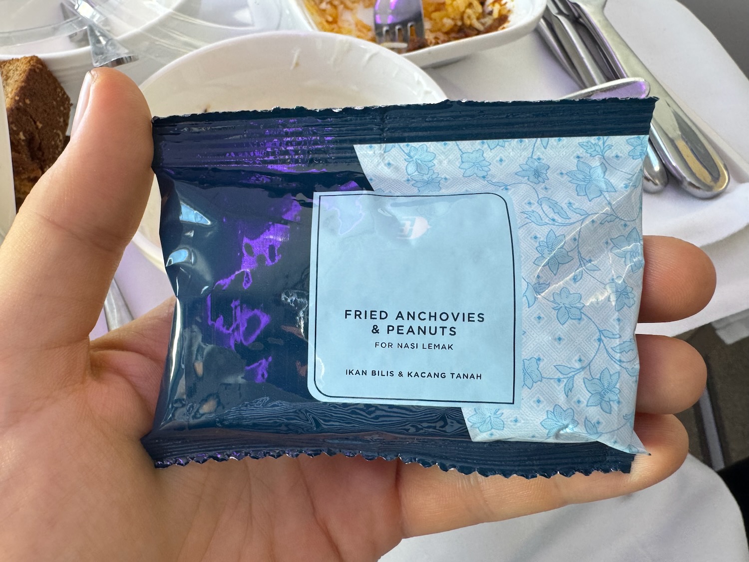 a hand holding a small blue package